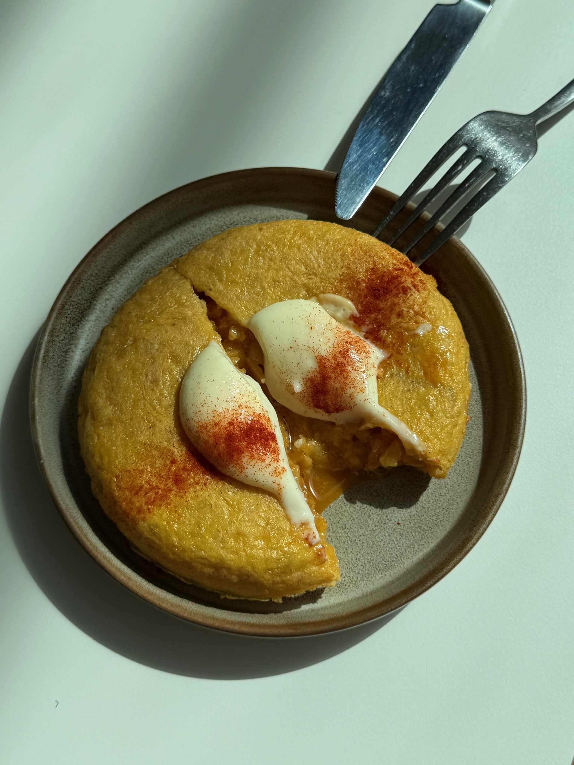 Spanish tortilla with a quenelle of alioli and a dusting of paprika on a stone plate